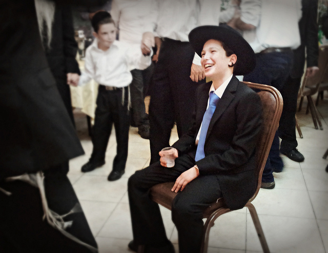 boy sitting in chair for bar mitzvah