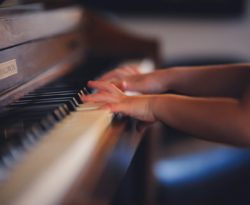 person playing upright piano