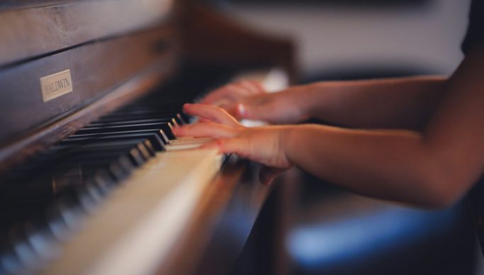person playing upright piano