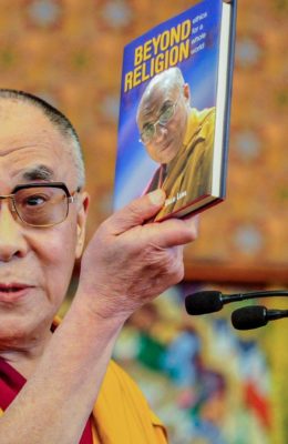 Man holding Beyond Religion book