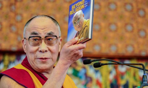 Man holding Beyond Religion book