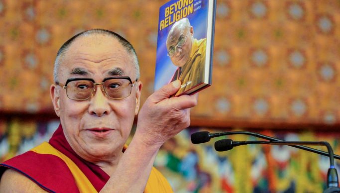 Man holding Beyond Religion book