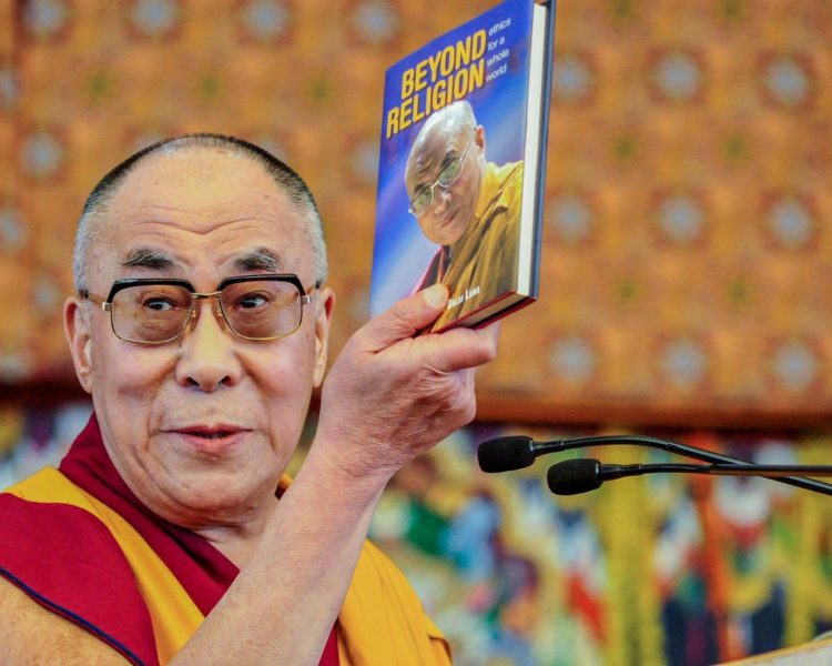 Man holding Beyond Religion book