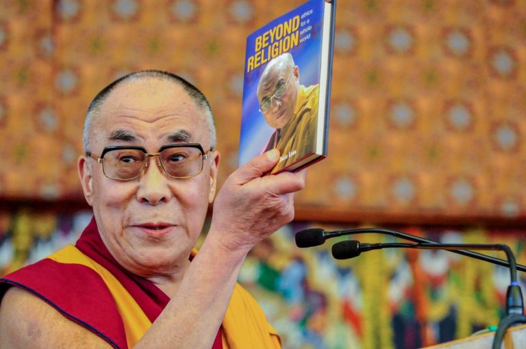 Man holding Beyond Religion book