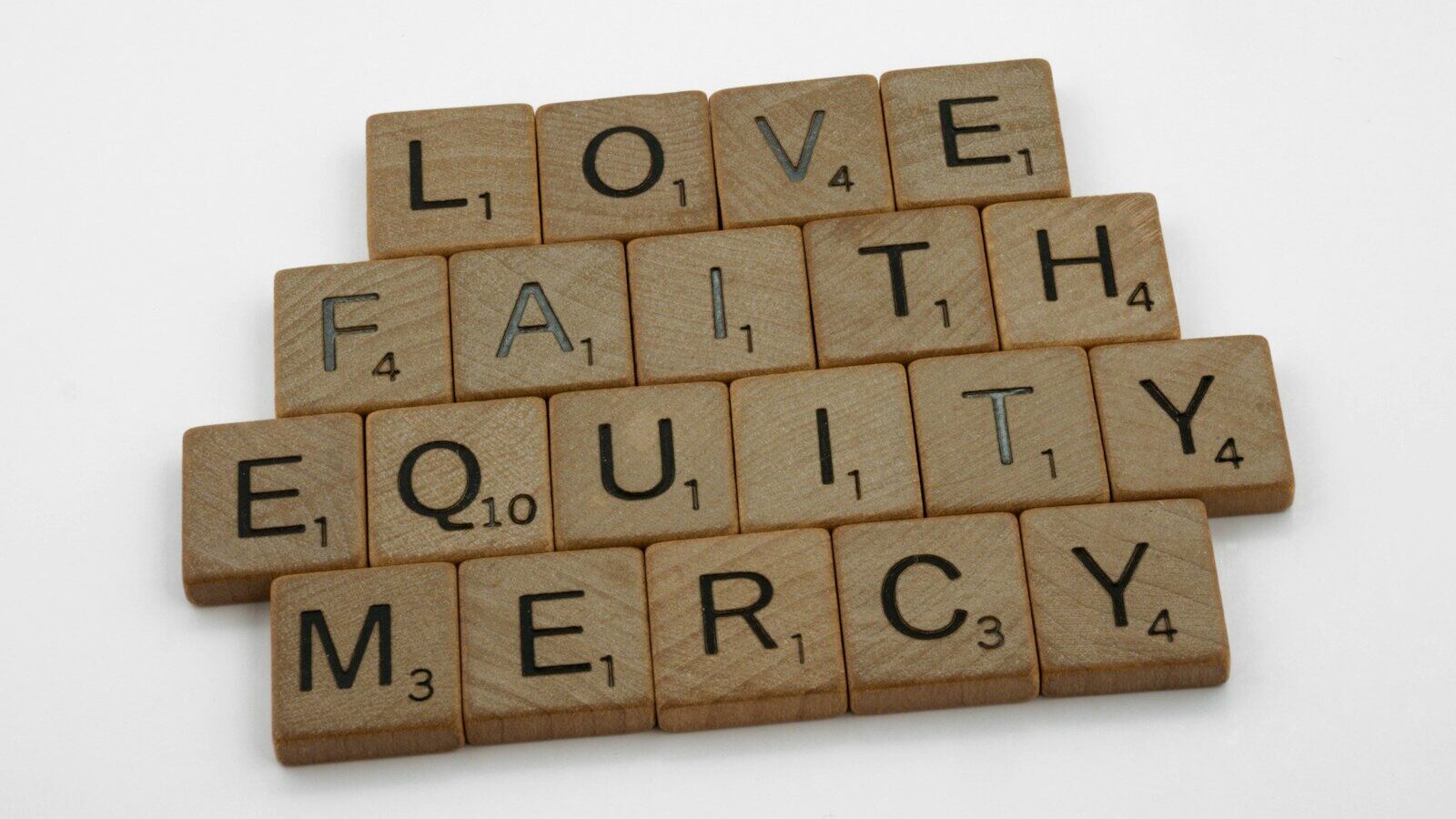 scrabble tiles spelling love, faith, equality, and mercy