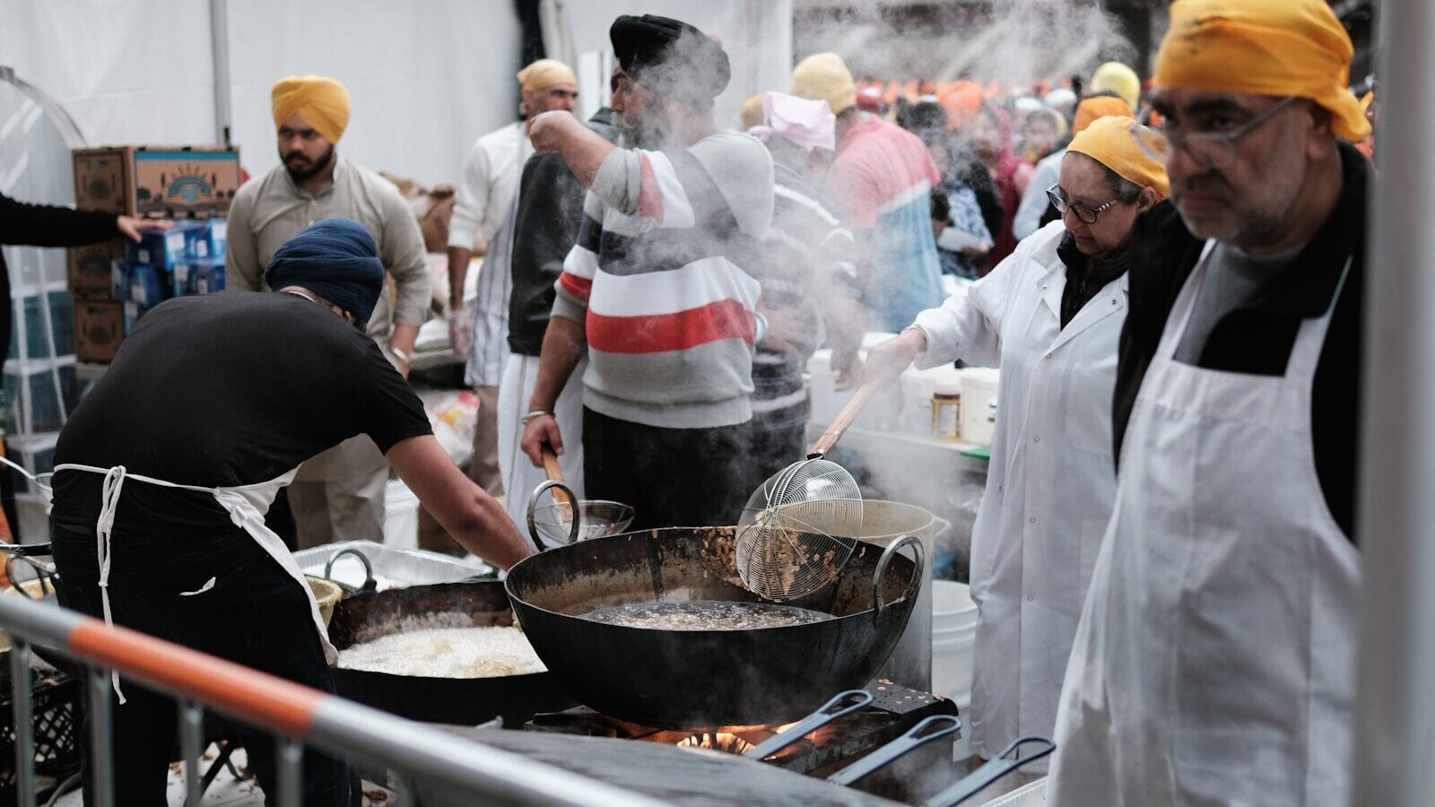 a group of men cooking food on top of a grill