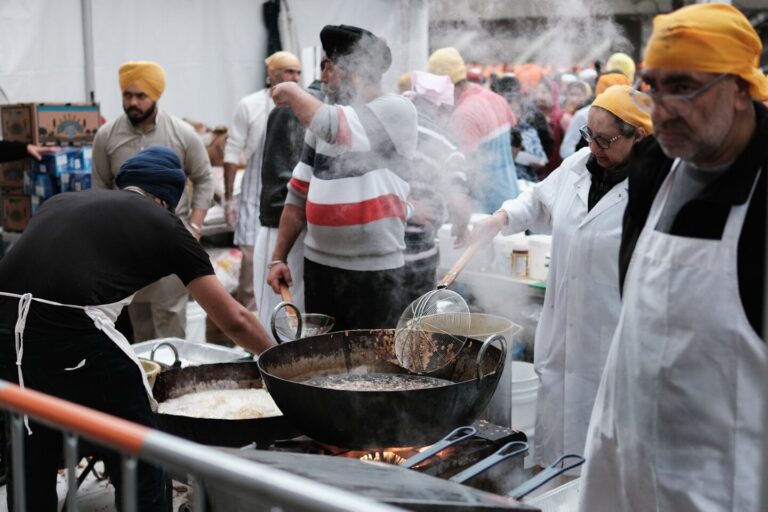 a group of men cooking food on top of a grill